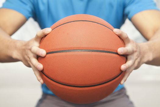 Close up of young man, midsection, holding a basketball