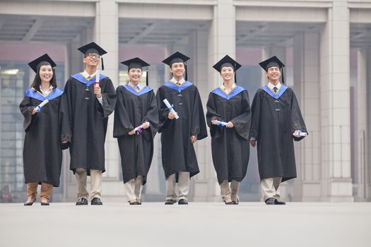 Group of Graduate Students Standing with Diplomas