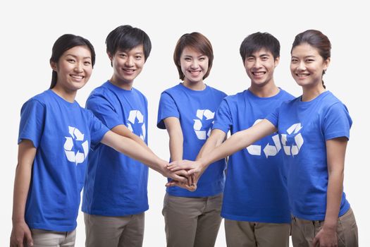 Five young people in recycling t-shirts with hands together, studio shot