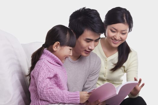 Family reading on the sofa, studio shot