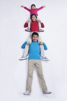 Family sitting on each others shoulders, imitation, studio shot