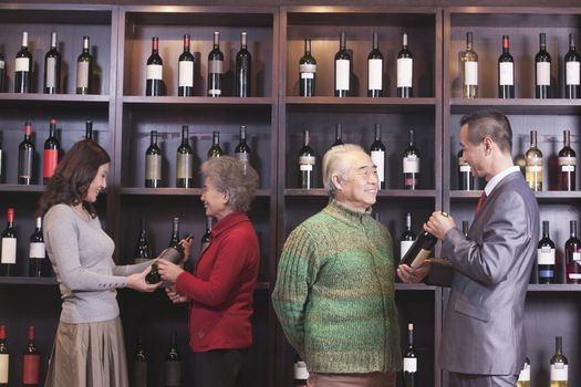 Four People Examining Wine at a Wine Store