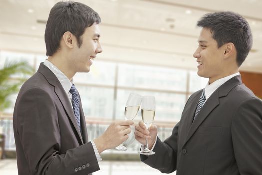 Two Businessmen Toasting Champagne Flutes