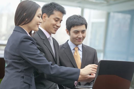 Three Business People Looking at Laptop