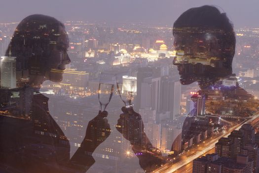 Double exposure of couple toasting with champagne flutes over night cityscape