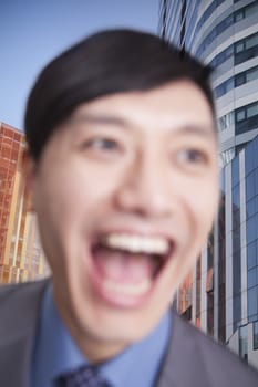 Close-up portrait of young man laughing, Focus on background
