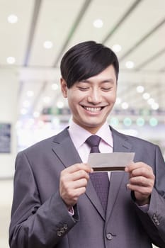 Young businessman looking at airplane ticket, Beijing