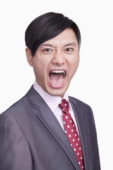Portrait of angry young businessman, studio shot