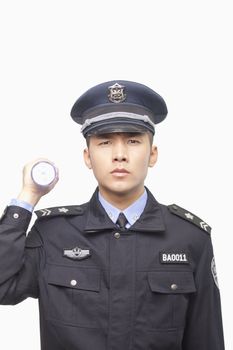 Police Officer Shining Flashlight, Studio Shot