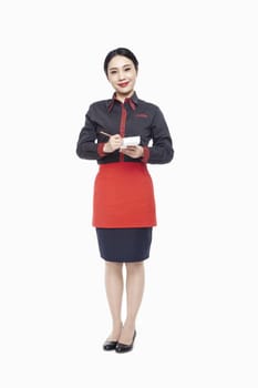 Young Waitress writing order on note pad, smiling, studio shot