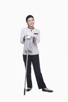 Young female caretaker with mop, studio shot