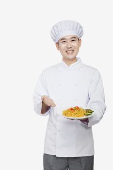 Chef showing prepared food, studio shot