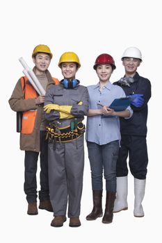 Group of construction workers standing against white background, smiling, portrait