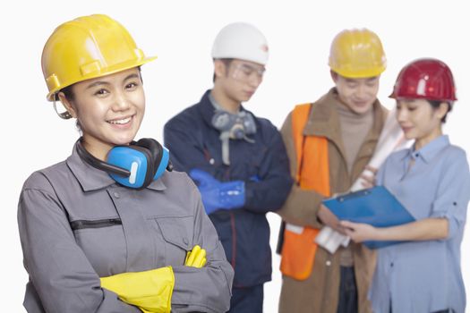 Four construction workers against white background, focus in foreground