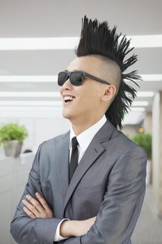 Well-dressed young man with Mohawk and sunglasses smiling