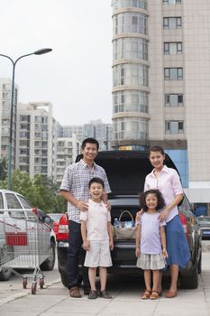 Family standing next to the car with shopping bags