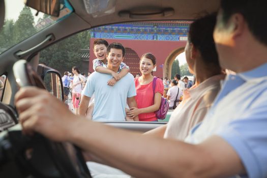 Grandparents driving and saying good bay to grandson and parents