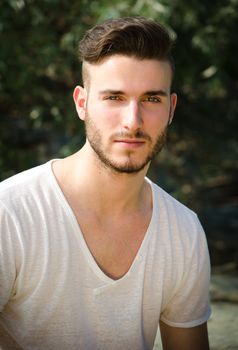 Portrait of attractive young man with white t-shirt, looking in camera