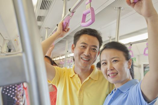 Adult couple standing in the subway and smiling, portrait