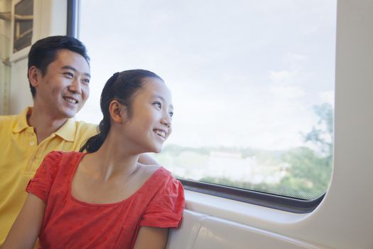 Father and daughter looking through the window in the subway