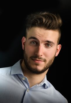 Portrait of attractive young man with nice expression, isolated on black background