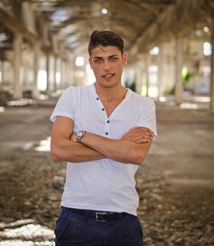 Handsome young man in abandoned, empty warehouse or old factory