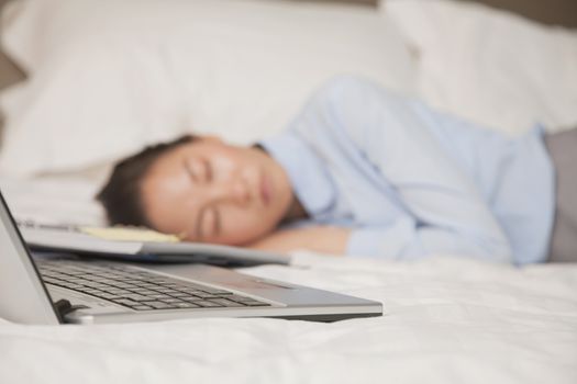 Overworked businesswoman in the bed with her laptop