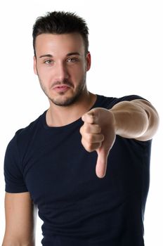Disappointed or displeased attractive young man doing thumb down sign, isolated on white