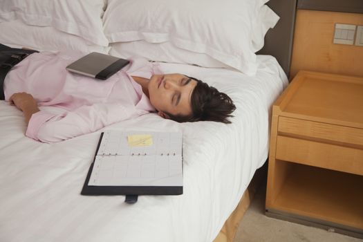 Overworked businessman sleeping in his bed