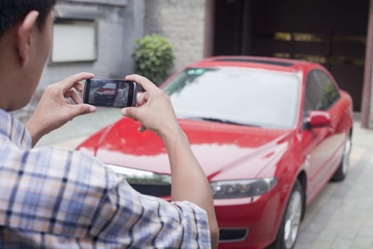 Young Man Taking a Picture of His Car