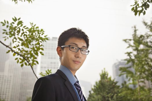 Young businessman standing in the park, portrait