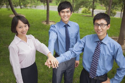 Business people putting their hand together as sign of team working