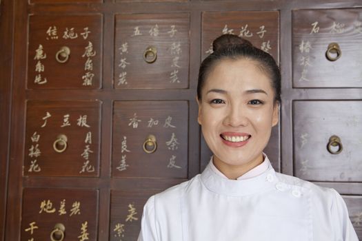 Portrait of Doctor In Front of Traditional Chinese Medicine Cabinet