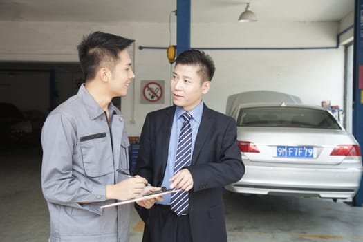 Garage Mechanic Explaining to Customer