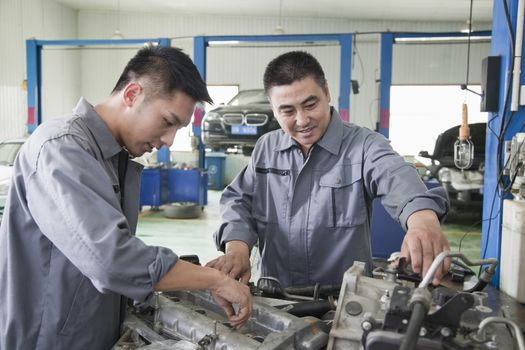 Two Mechanics Working on Car Engine