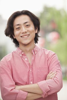 Smiling Young Man with Long Hair in Nanluoguxiang, Beijing, China