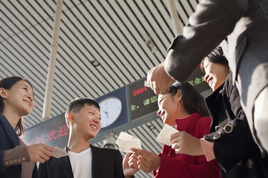 Group of people looking at tickets at the railway station