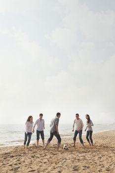 Young Friends Playing Soccer on the Beach