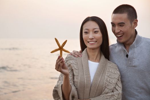 Young Couple Looking At a Seashell