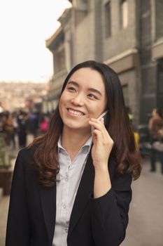 Young business woman on cell phone in Houhai, Beijing, China