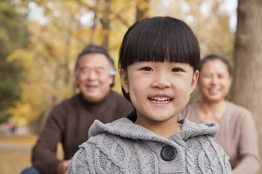 Grandparents and granddaughter in park