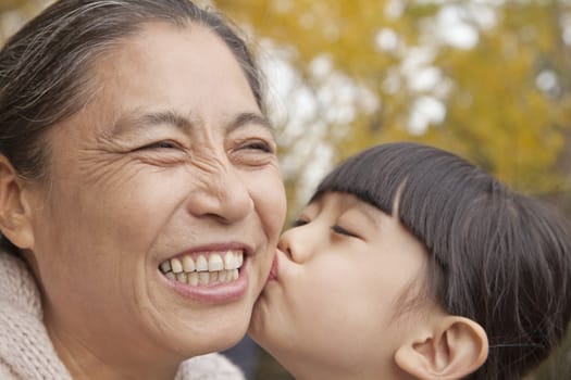 A girl kissing her grandmother