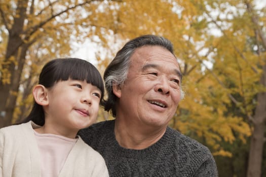 Grandfather and granddaughter in park