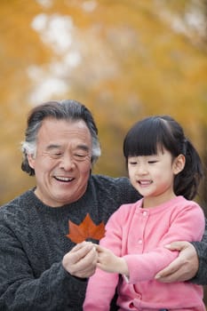 Grandfather and granddaughter in park