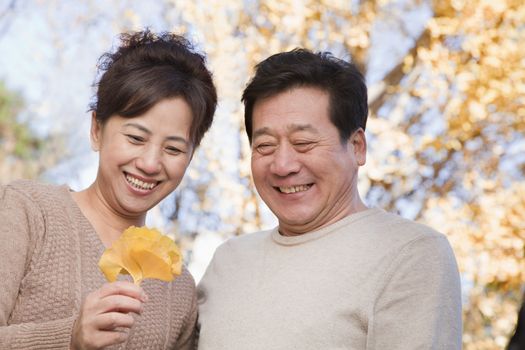 Mature Couple Looking at the Leaf in the Park