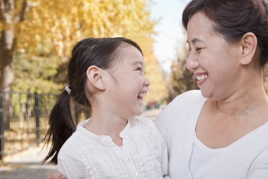 Grandmother and Granddaughter Enjoying the Park in Autumn