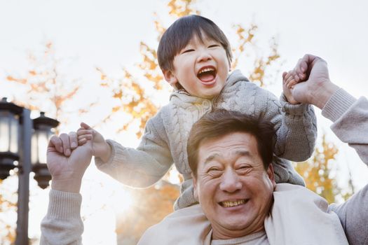 Grandfather Carrying Grandson on His Shoulders