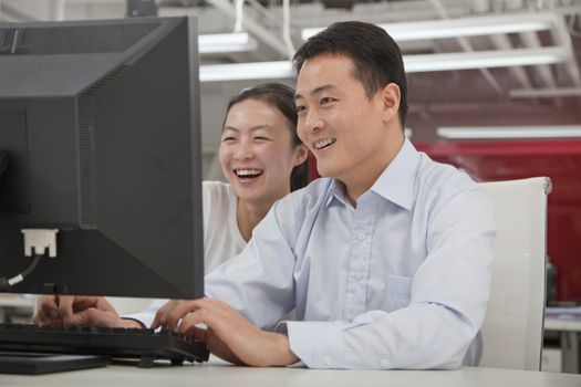 Happy business people working on their computer in the office