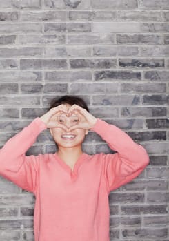 Portrait of Young Woman Making Heart with Fingers