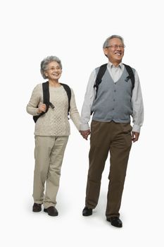 Senior couple with backpacks walking